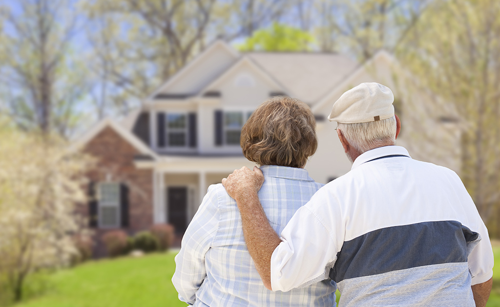 Pareja de adultos mayores observando casa desde lejos