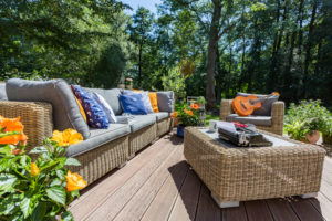 Veranda of a house in a sunny day with the garden wicker furniture