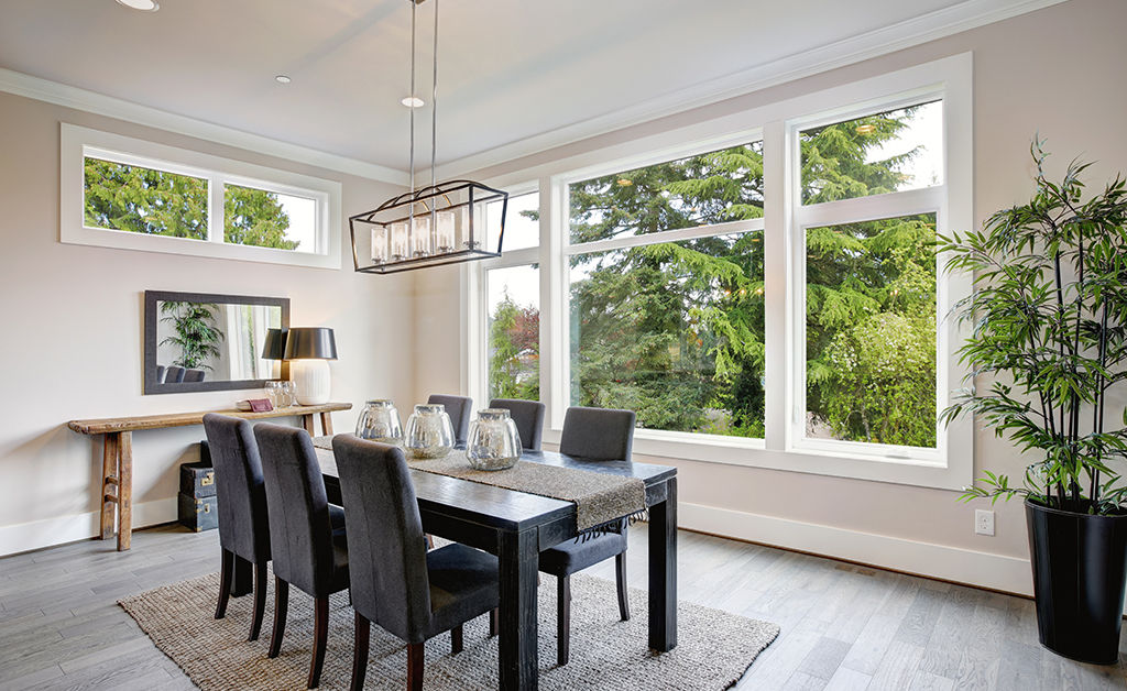 Modern dining room with big windows and beautiful green view