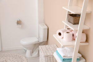 Toilet paper rolls on shelving unit in bathroom