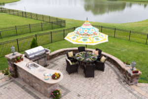 Outdoor living space on a brick patio overlooking a tranquil lake