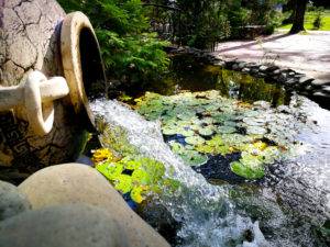 water coming out from a vase in a garden