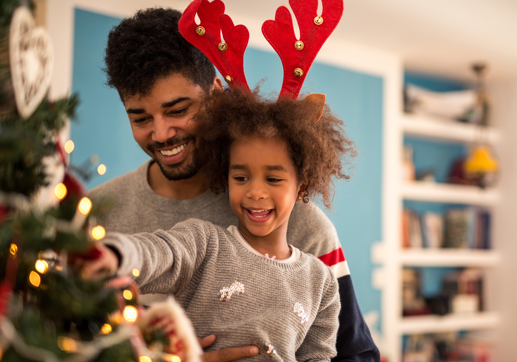 dad with kid decorating christmas tree
